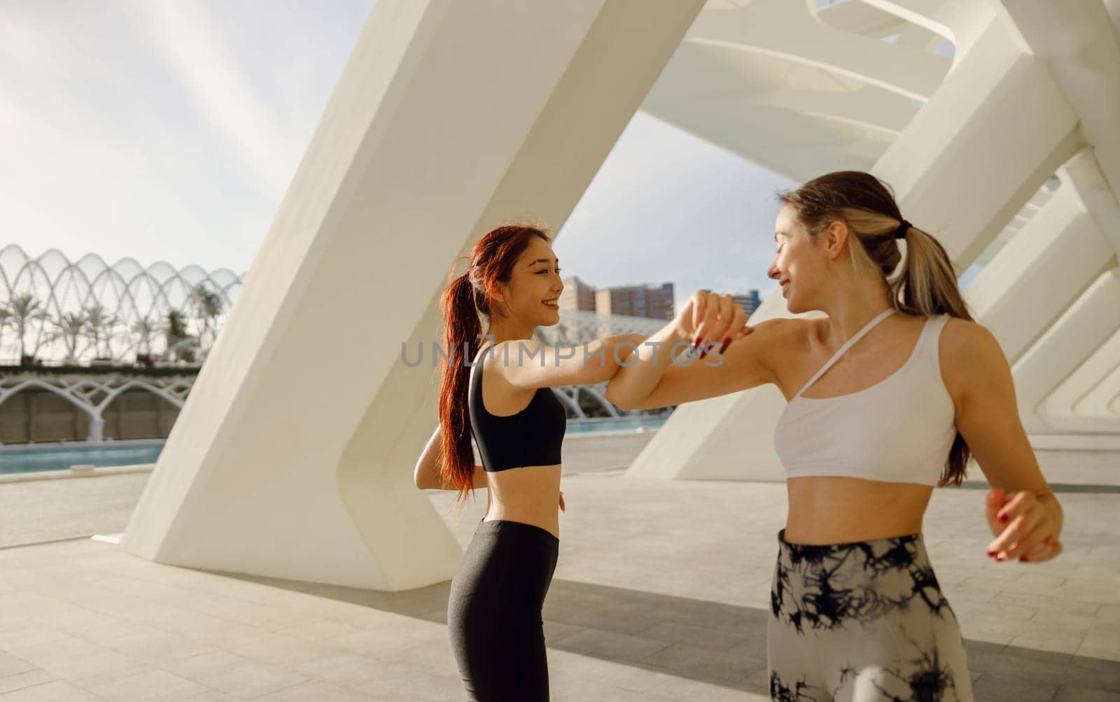 Sporty women non-contact greeting together outdoor meeting for fitness training or running outside by Yaroslav_astakhov