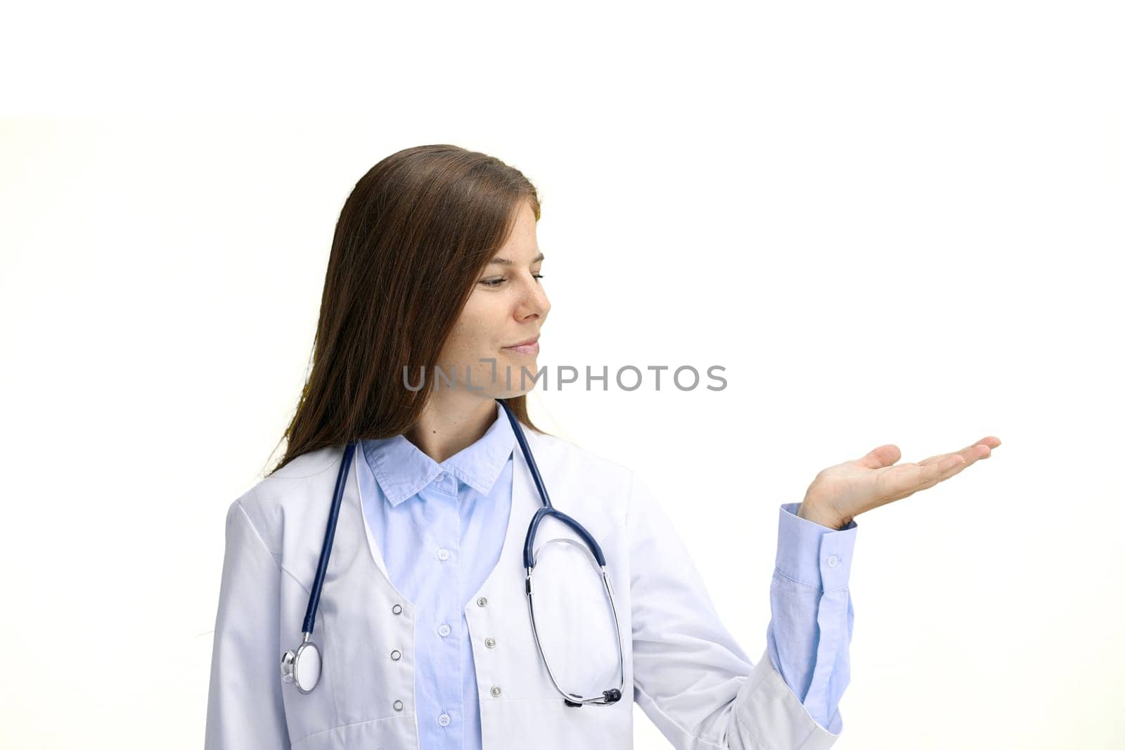 Female doctor, close-up, on a white background, pointing to the side.