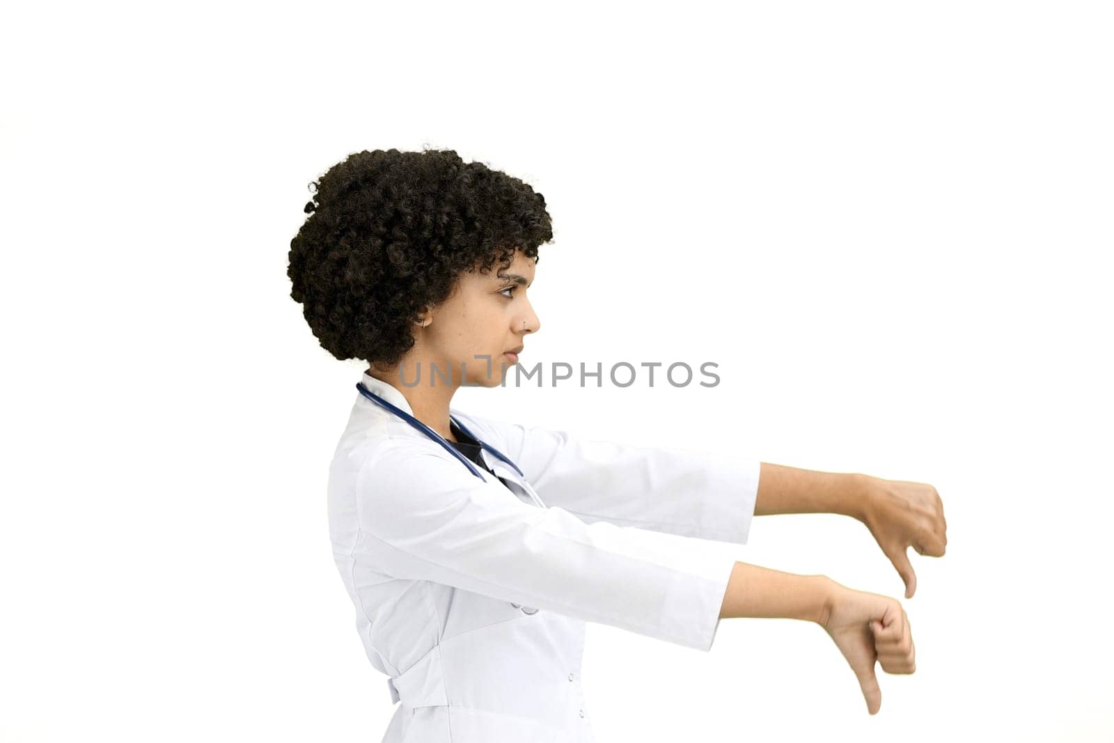 Female doctor, close-up, on a white background, shows thumbs down.