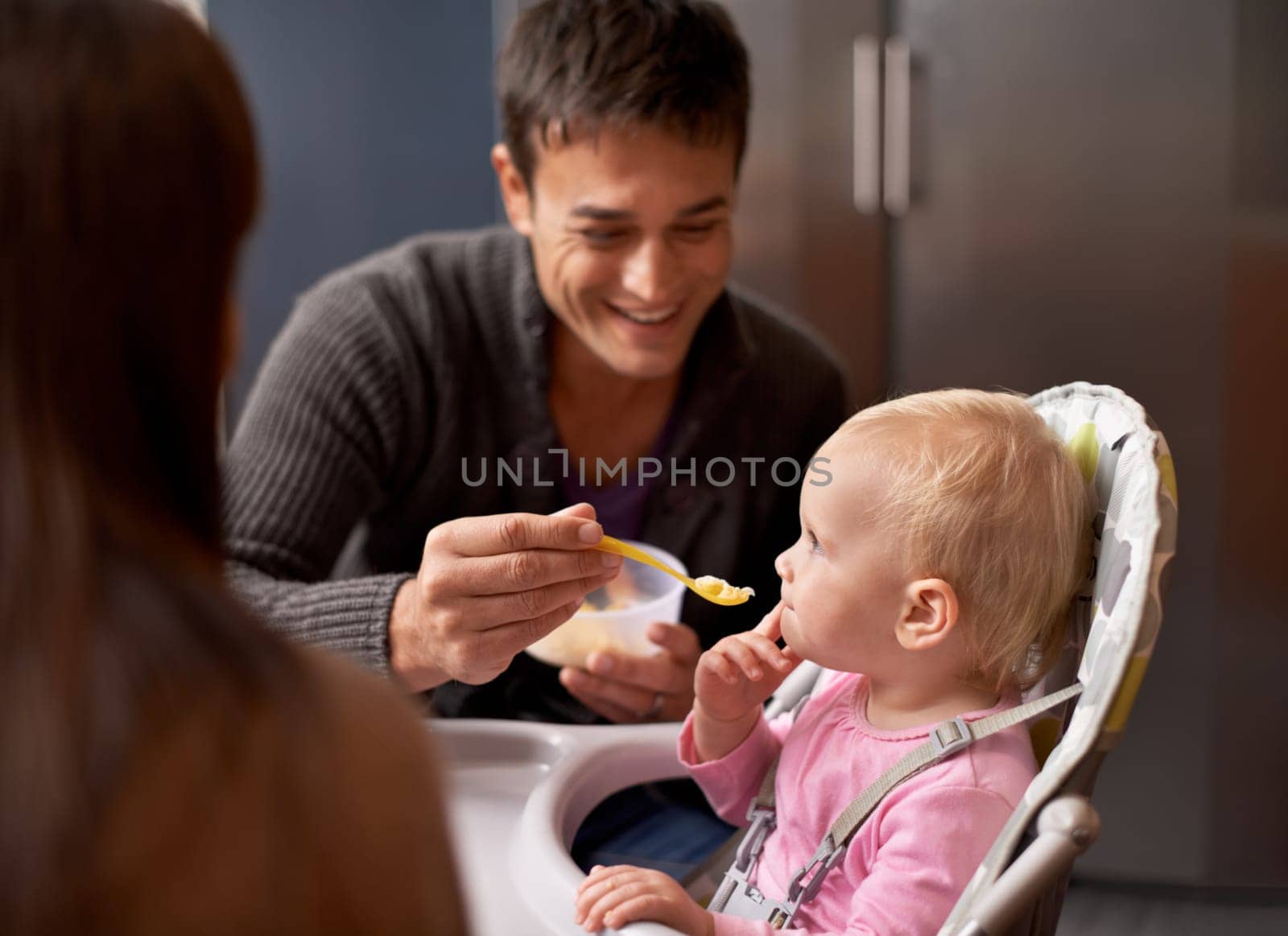 Happy, baby and dad in feeding at home in the morning with nutrition and wellness. Father, family and food of a infant with development and breakfast in a house kitchen with love, support and care by YuriArcurs