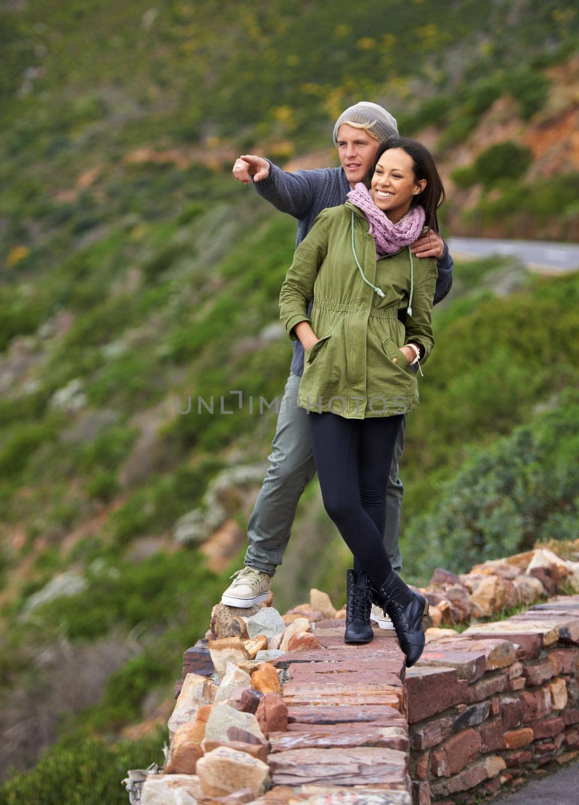 Happy couple, hiking and nature in travel for sightseeing, journey or outdoor view together. Young man and woman with smile enjoying holiday, vacation or pointing in natural environment on mountain by YuriArcurs