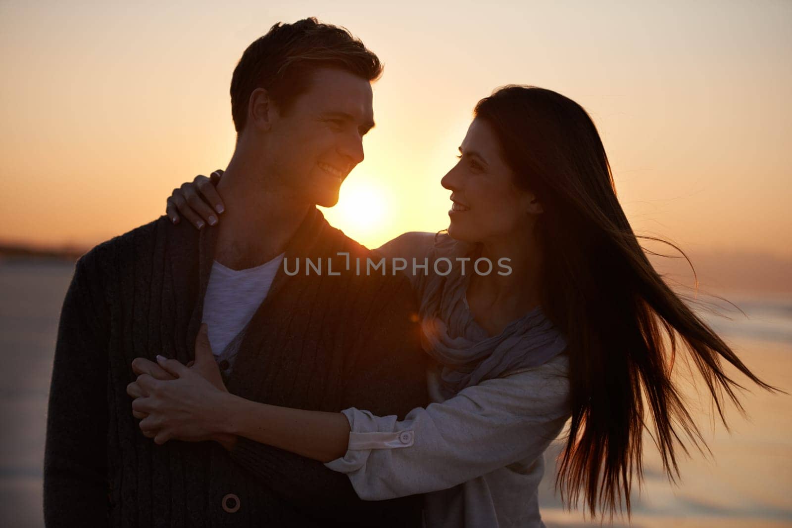 Couple hug, sunset on beach and travel for bonding, romance outdoor with love and trust. Happiness, support and loyalty with people in relationship, sunshine and adventure together with smile.