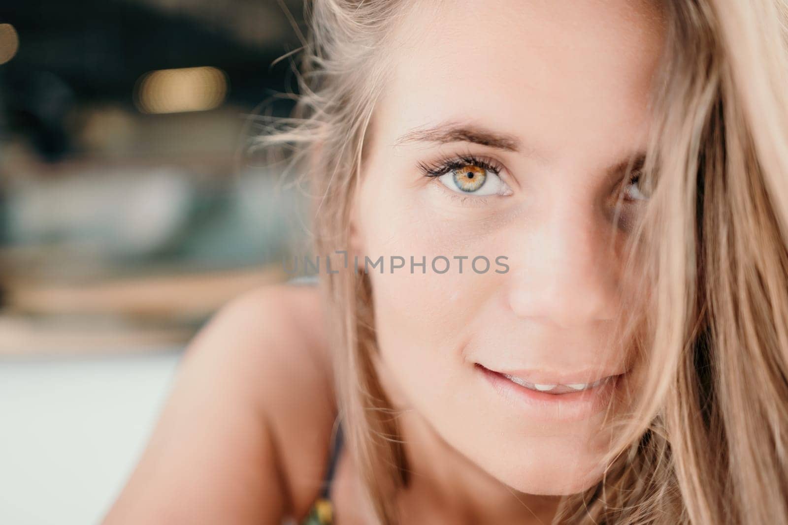 Happy woman portrait in cafe. Boho chic fashion style. Outdoor photo of young happy woman with long hair, sunny weather outdoors sitting in modern cafe. by panophotograph