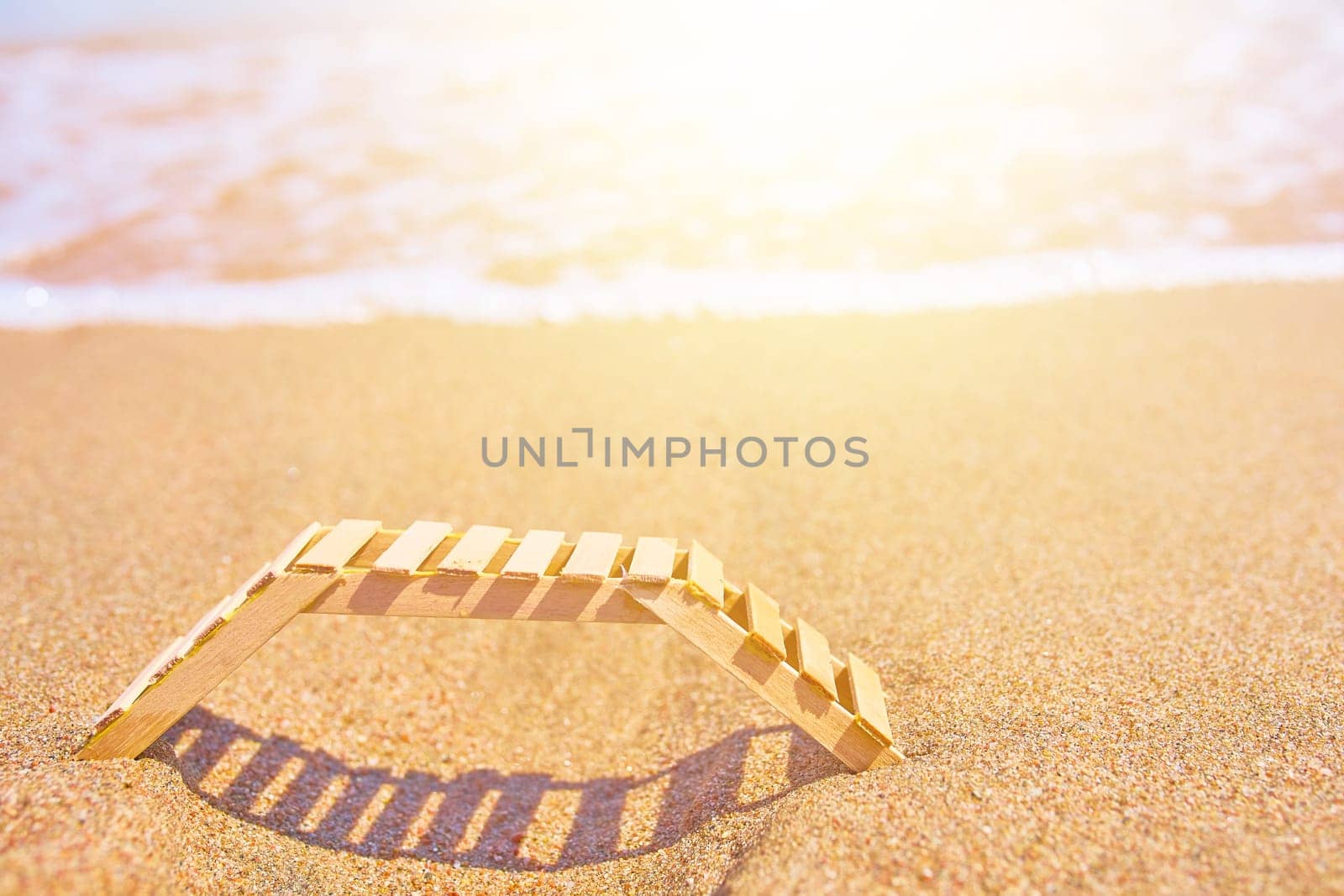 Wooden deckchair on a tropical sand beach. Wooden deckchair on a tropical sand beach overlooking the sea water.