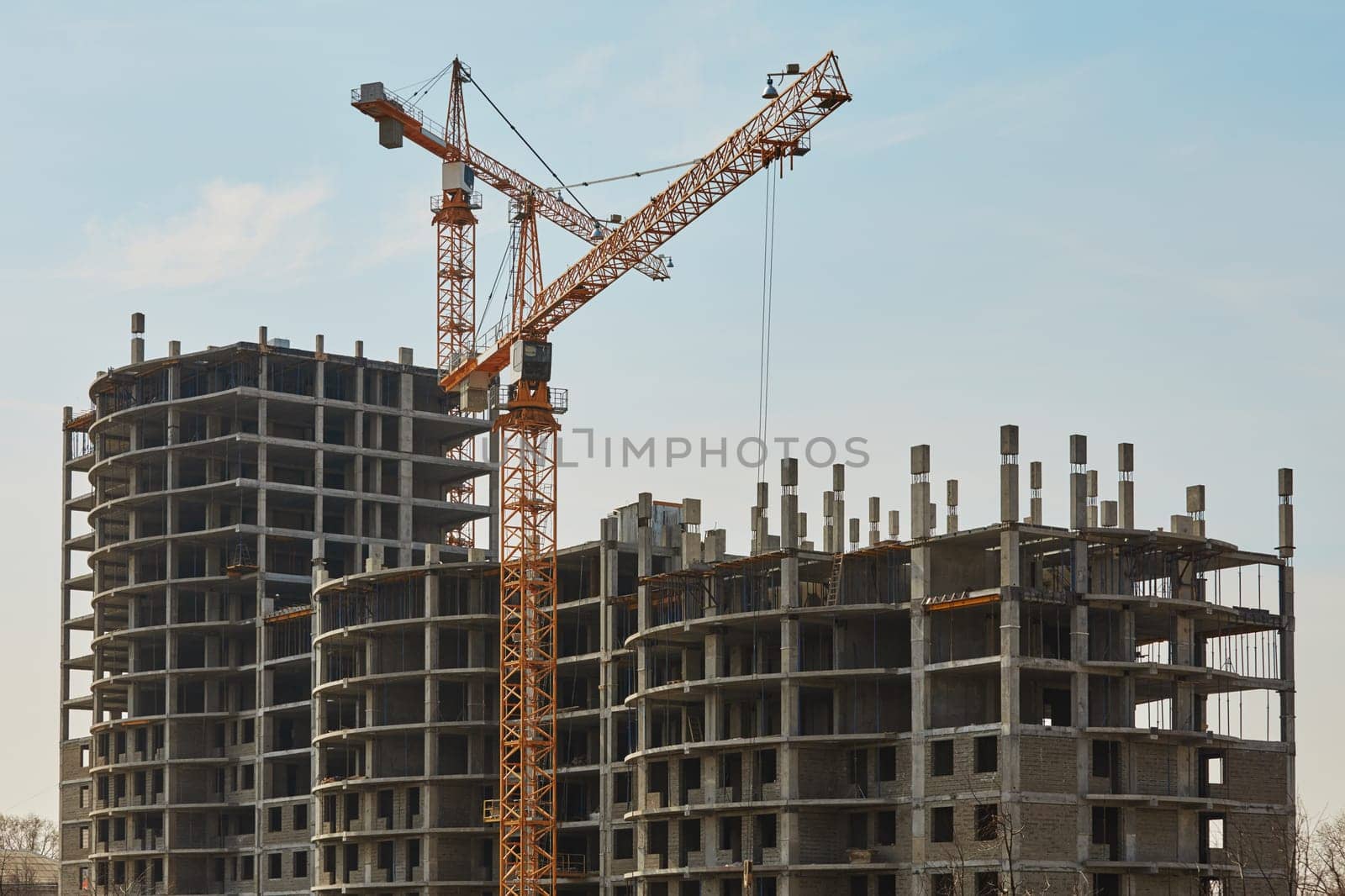 Building construction site with cranes under clear sky