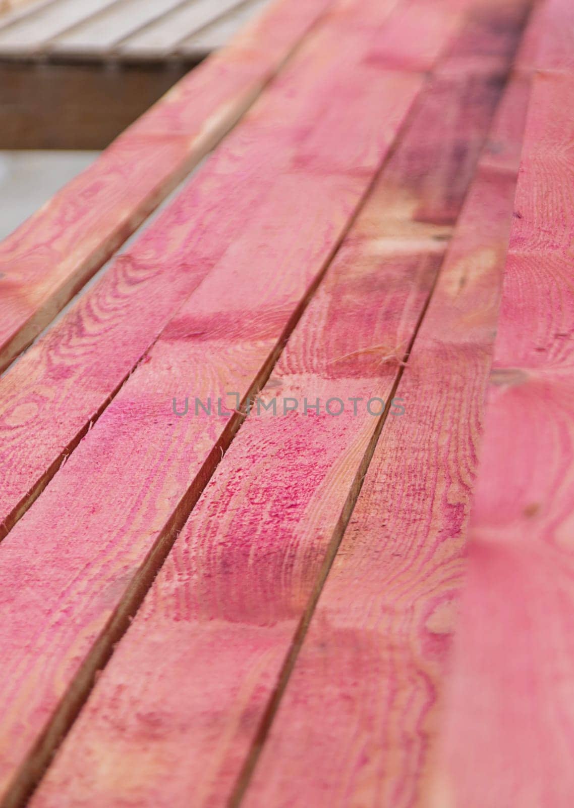 A man treats a board with a red antiseptic. selective focus. Nature.