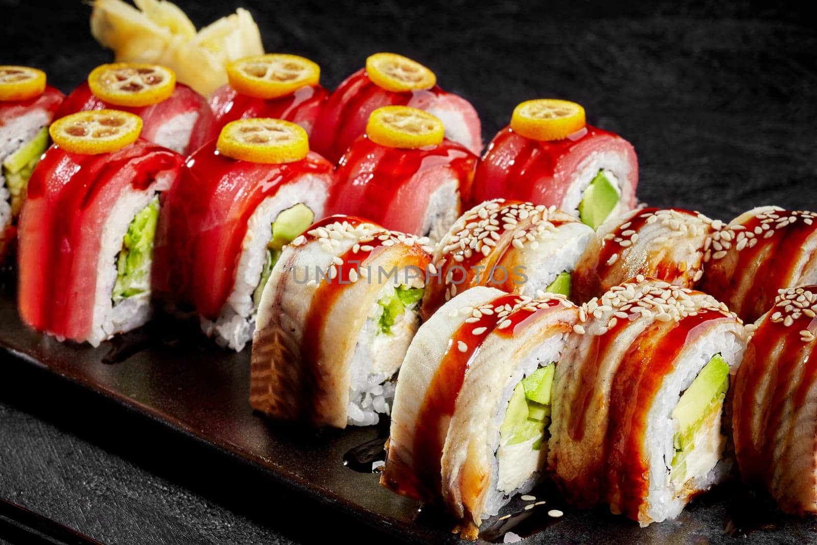 Philadelphia rolls topped with eel and tuna on black background by nazarovsergey