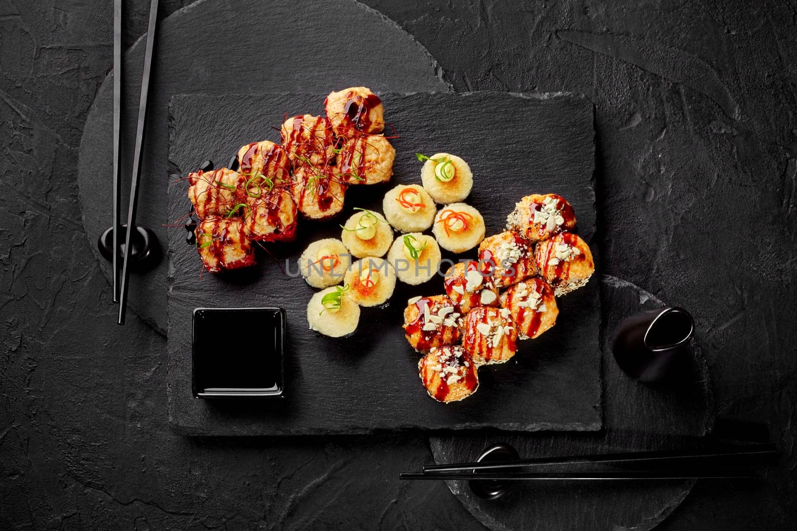 Baked sushi rolls with cheese hats served on slate plates by nazarovsergey