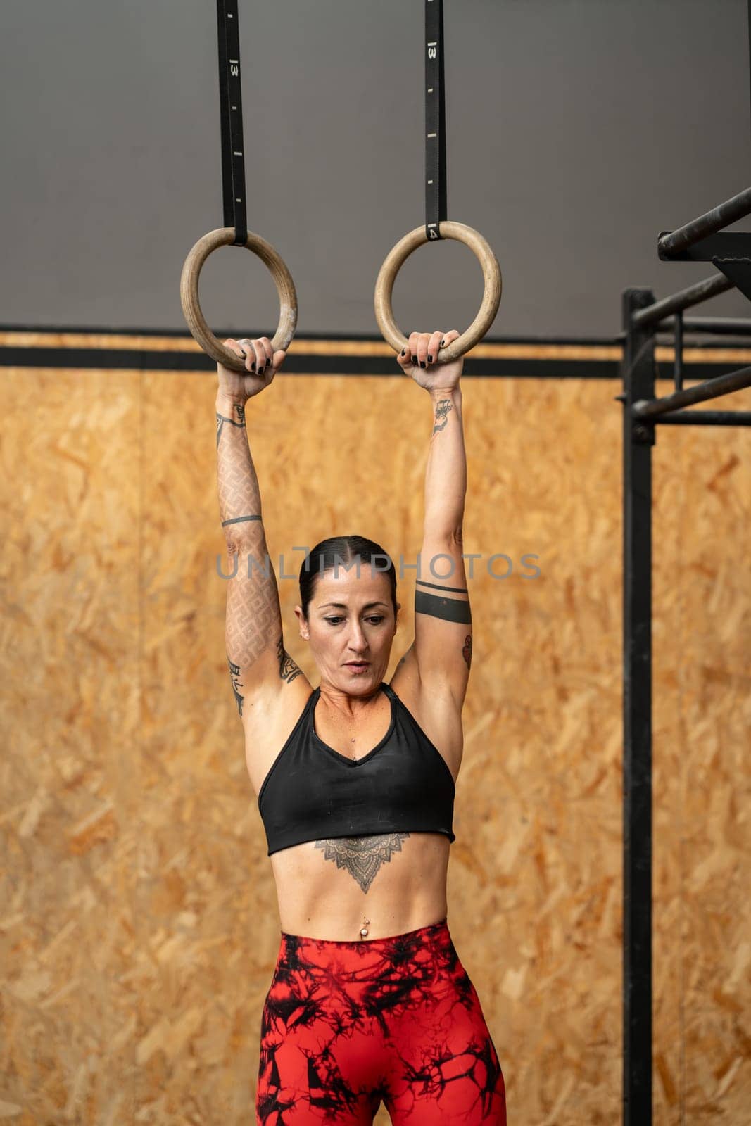 Vertical photo of a women training olympic ring in cross training center