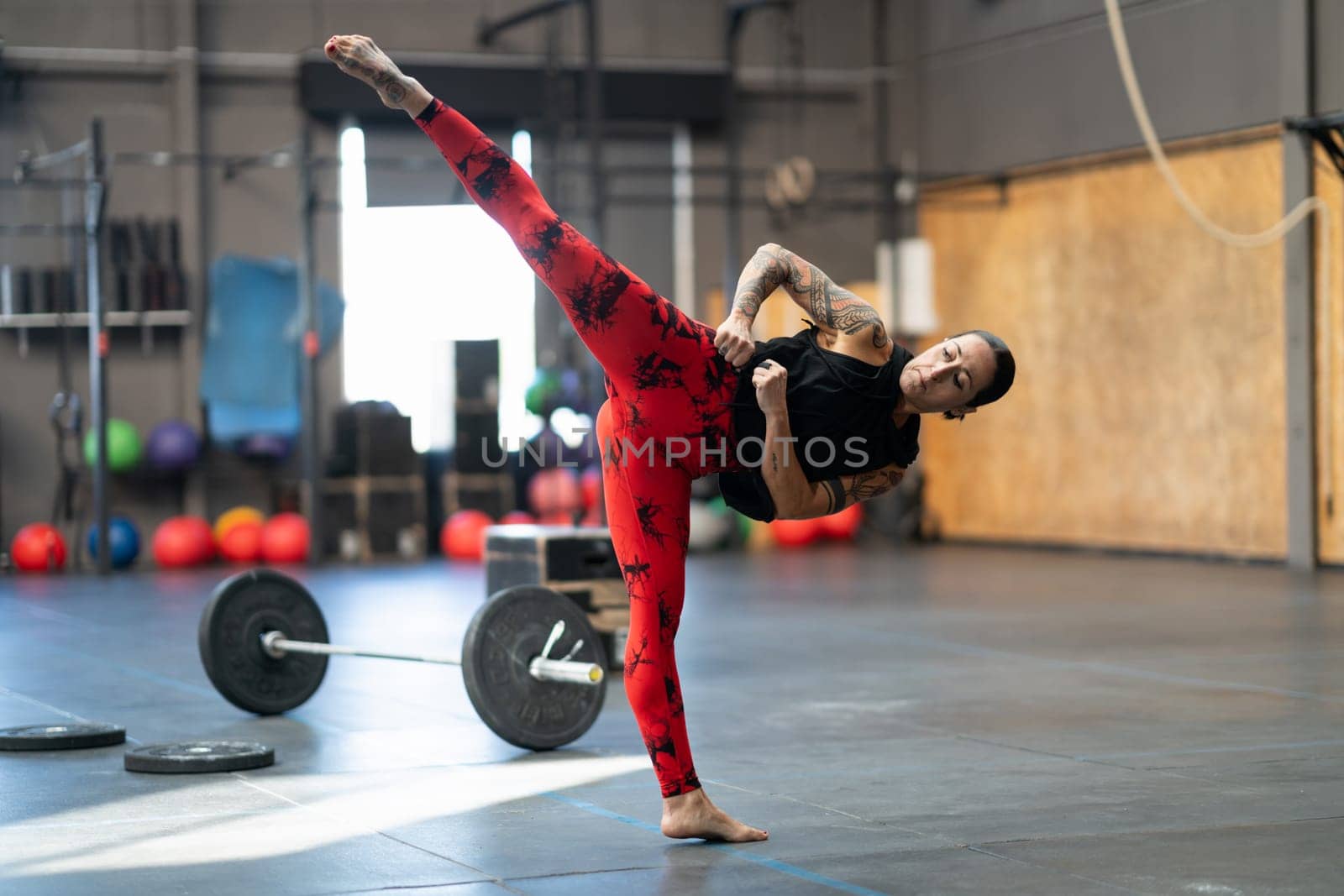 Flexible sportive woman kicking in the gym by javiindy