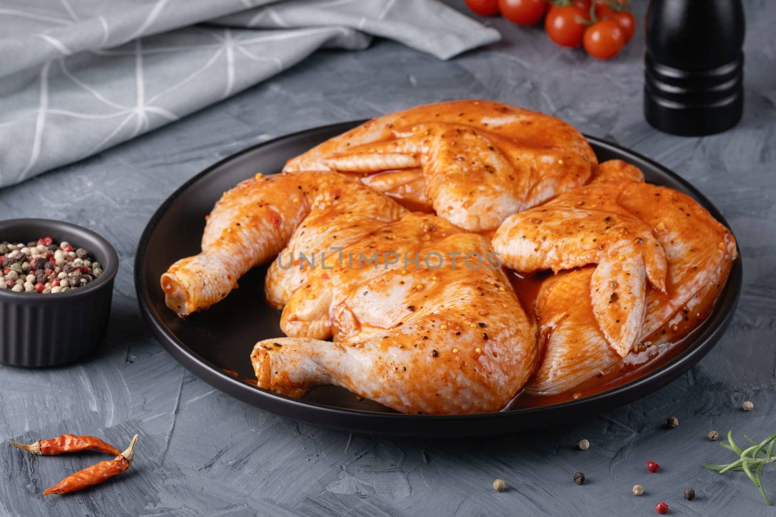 Ready to roast raw Chicken Tabaka set, on gray stone table background.