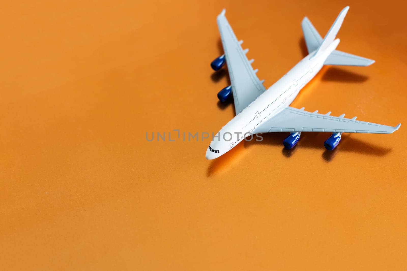 Airplane on orange background, flat lay, travel concept.
