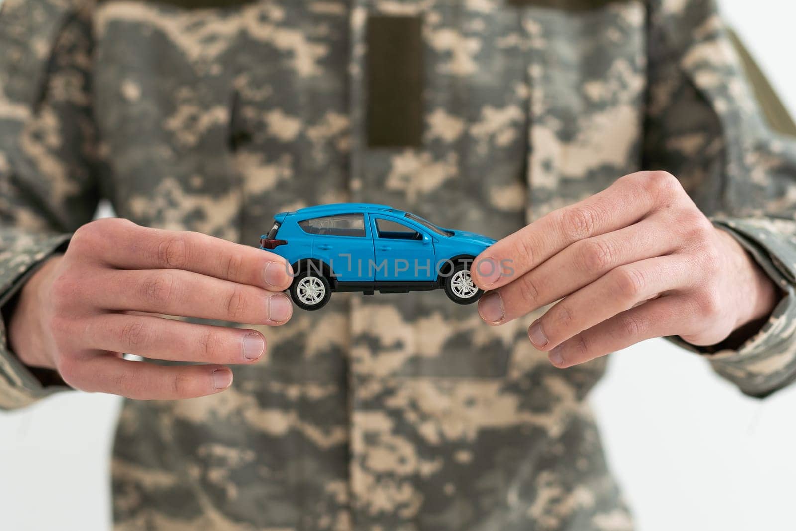 a military man is holding a toy car