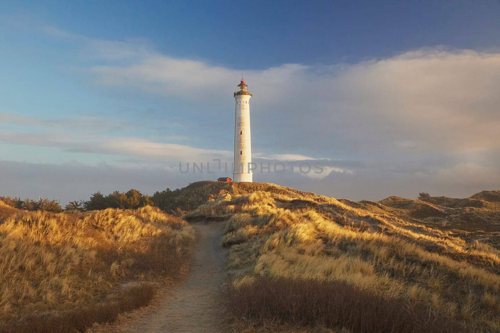 Lighthouse at sunset in a coastal city Hvide Sande Denmark.