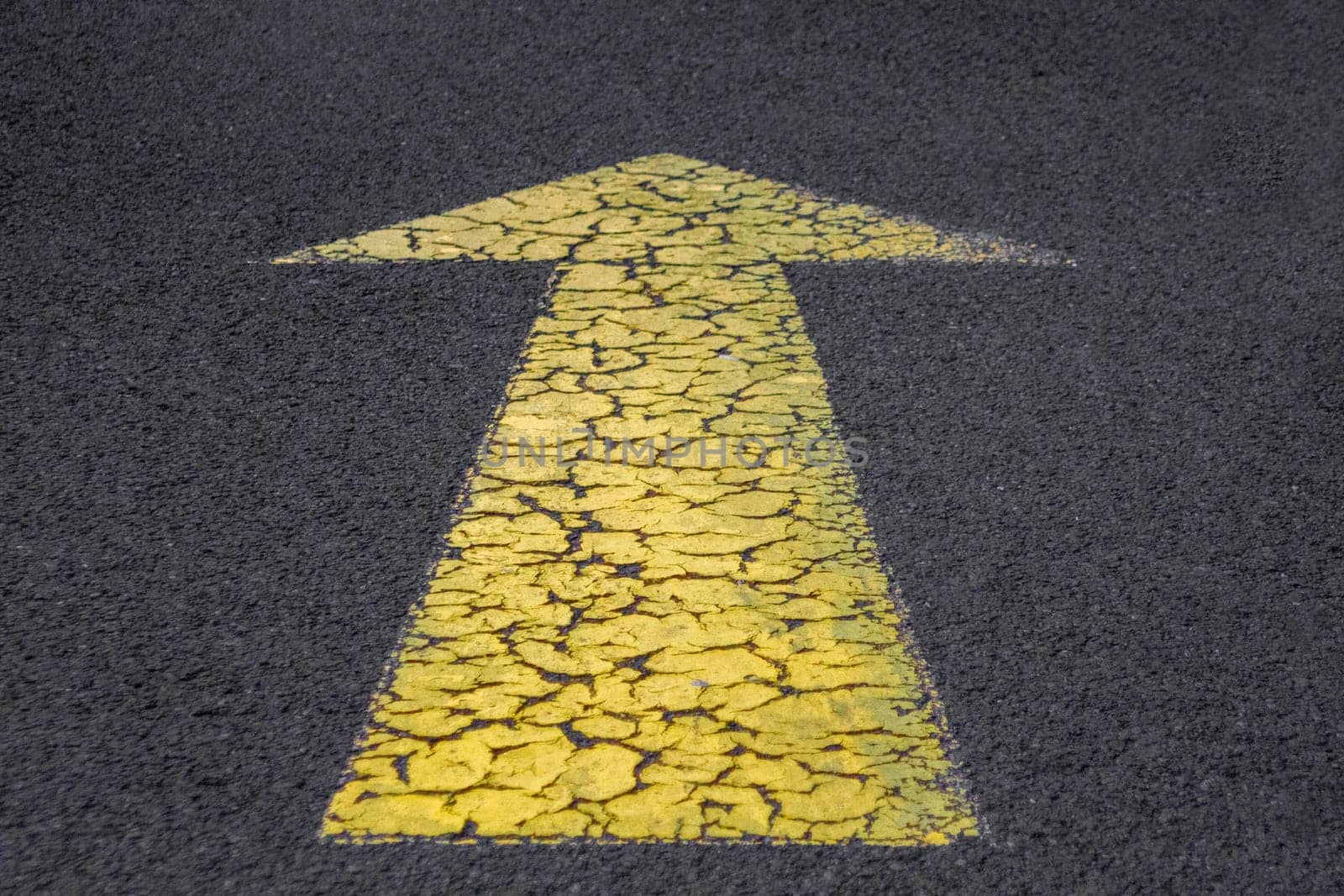 Yellow arrow on the asphalt. High quality photo