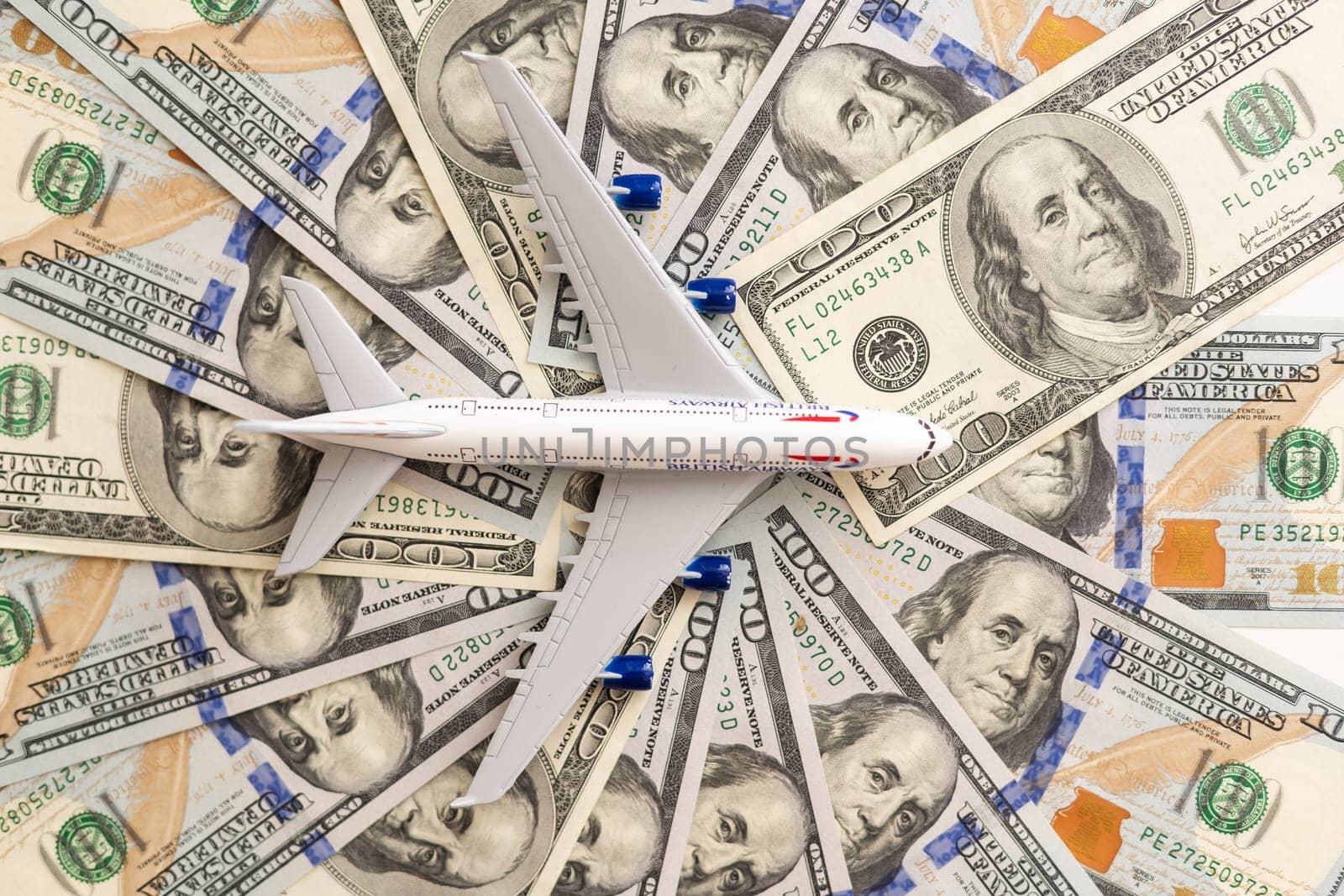 Model passenger aircraft on a background of dollar bills. High quality photo