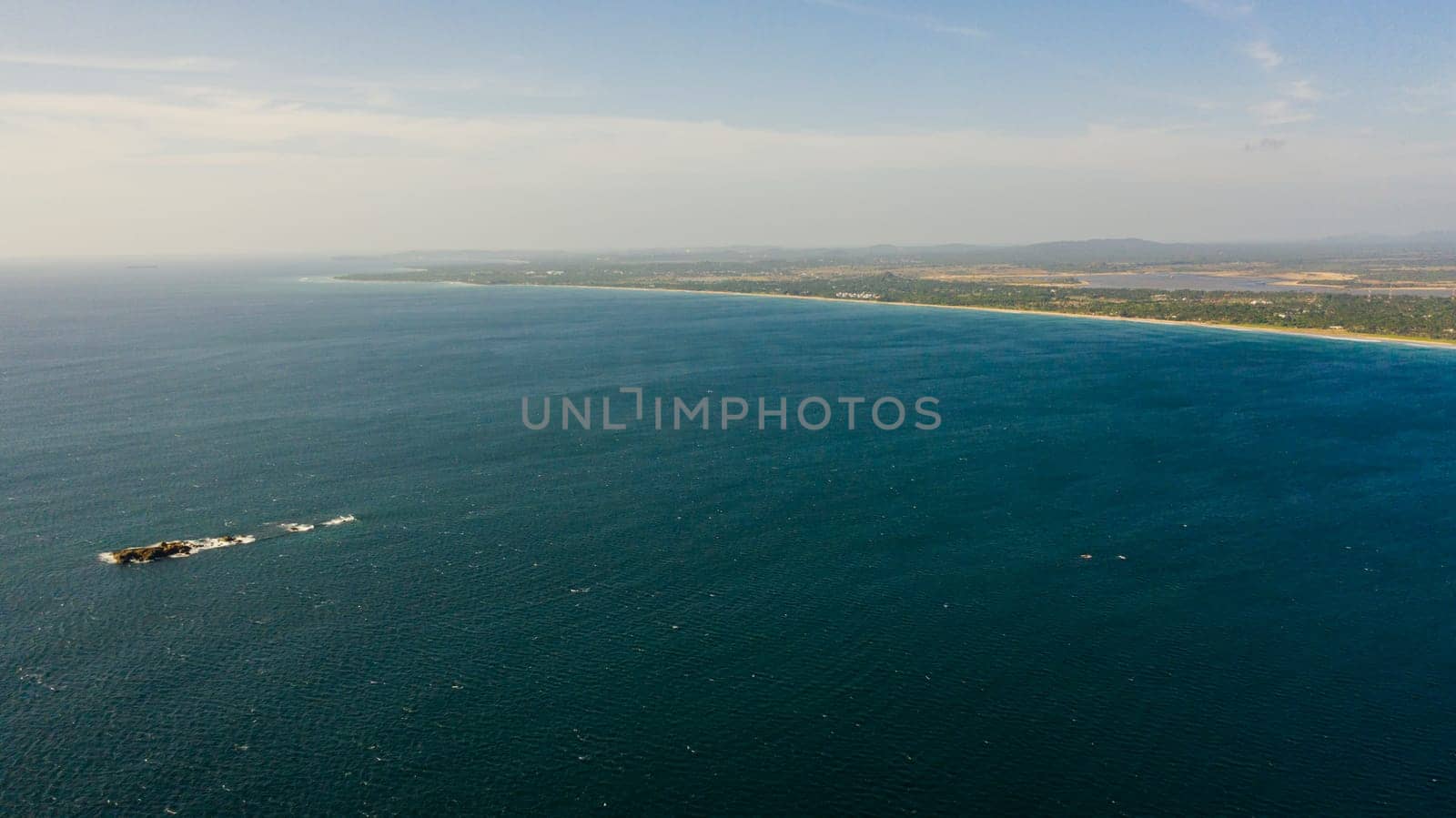 Coastline of the island with a sandy beach. Nilaveli Beach, Trincomalee, Sri Lanka.