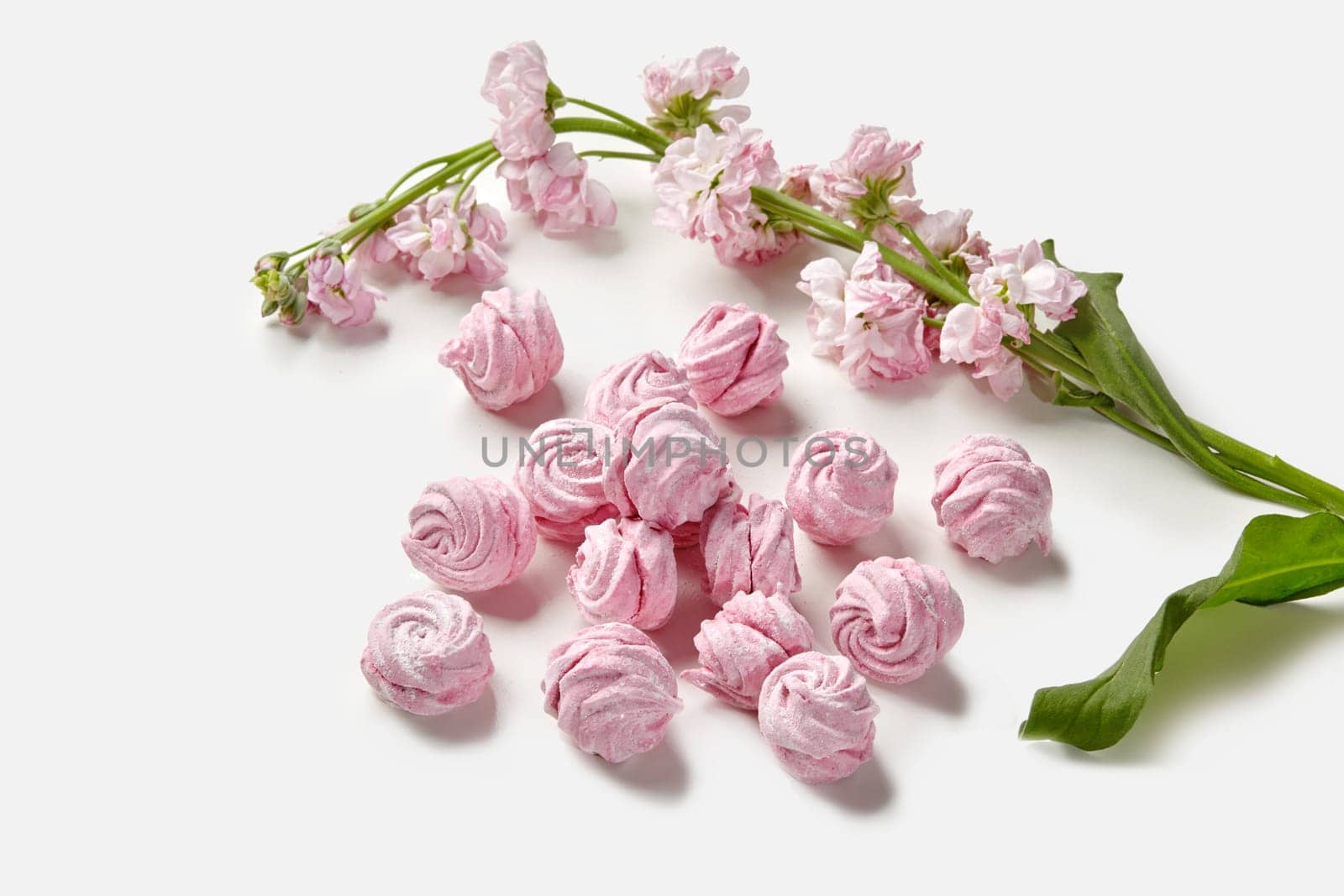 Natural berry pink marshmallow swirls with flowers on white by nazarovsergey
