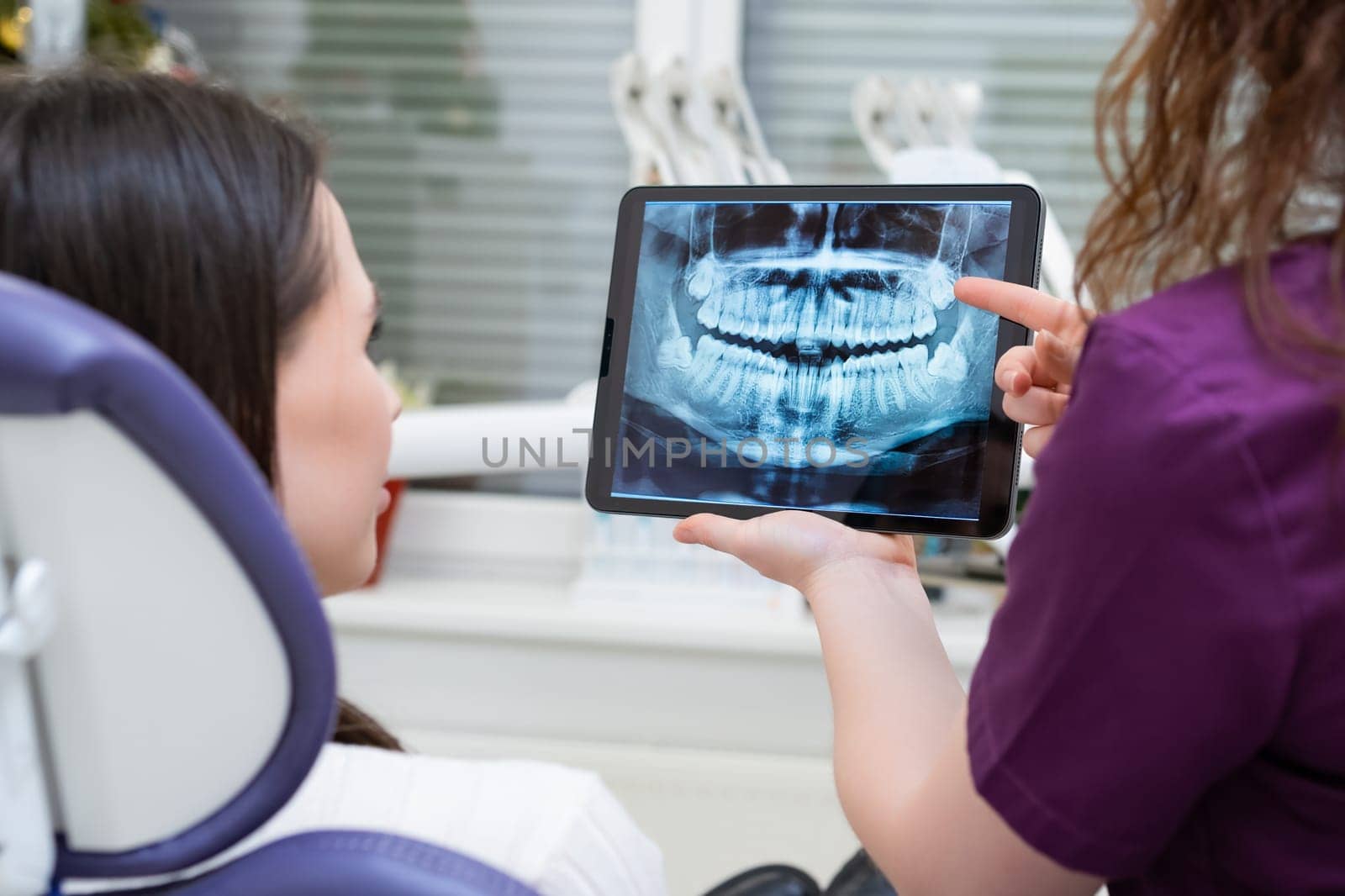 Dentist presents the patient with an X-ray and engages in a discussion about treatment options