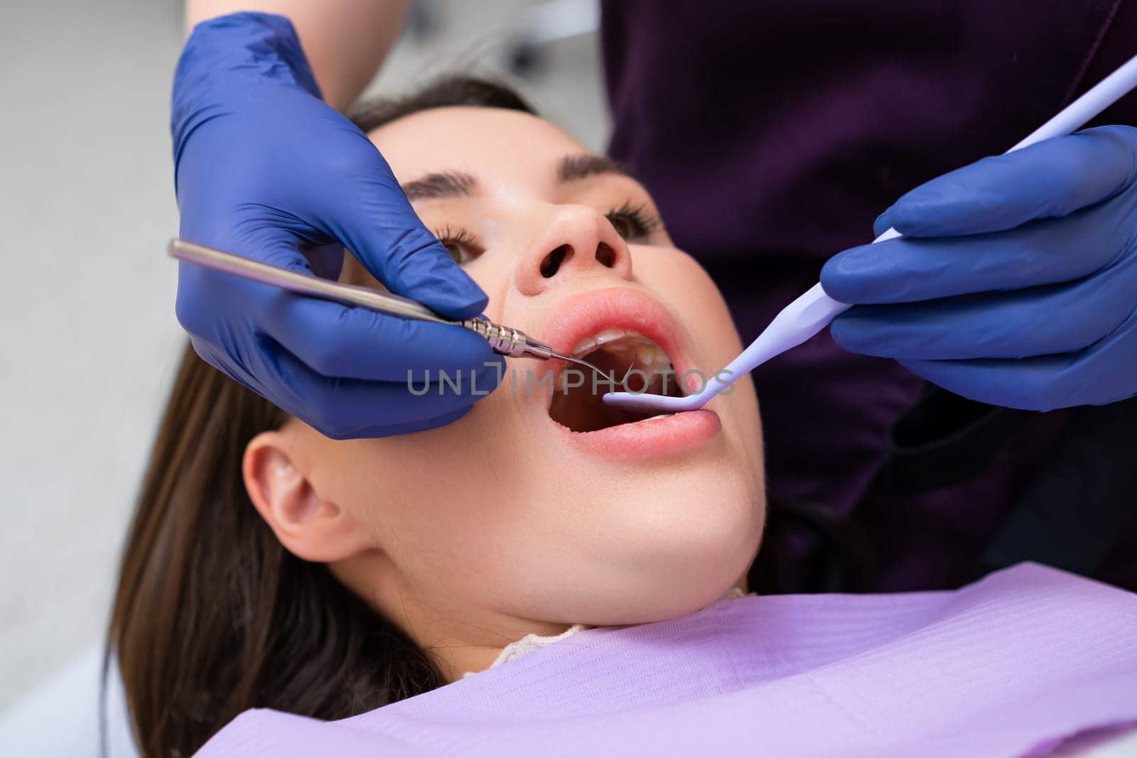 Dentist examining a patients teeth in dental office