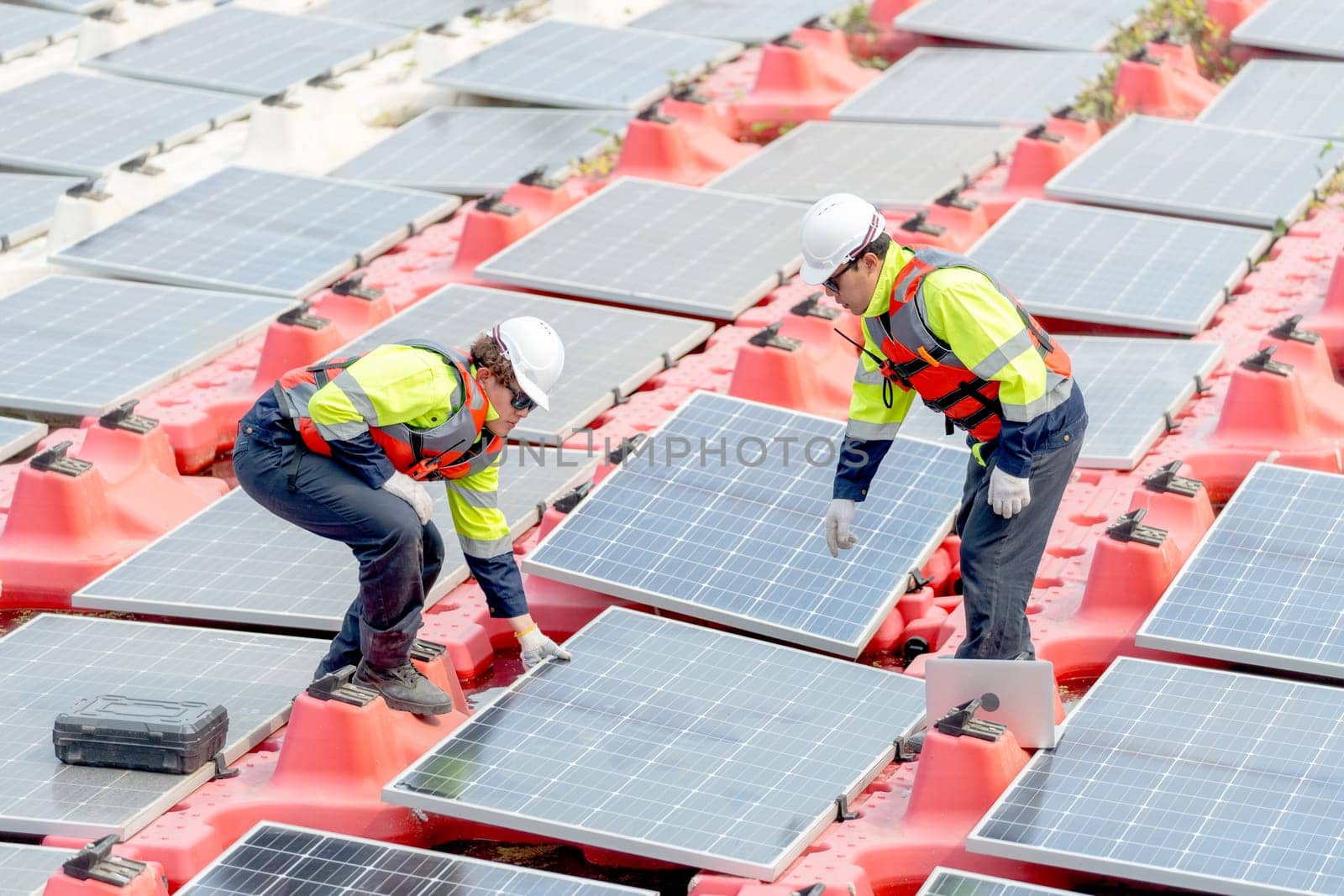 One professional technician worker hold solar cell panel and discuss with co-worker during install or set up or maintenance in concept of green energy power plant for good environment.