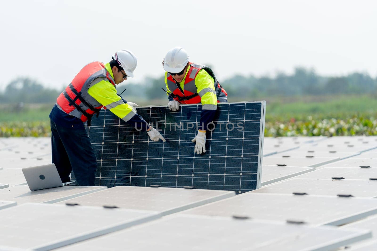 Close up one technician worker stand and point to area of problem and work with co-worker who stand and touch to check the problem of solar cell panel in the network system.