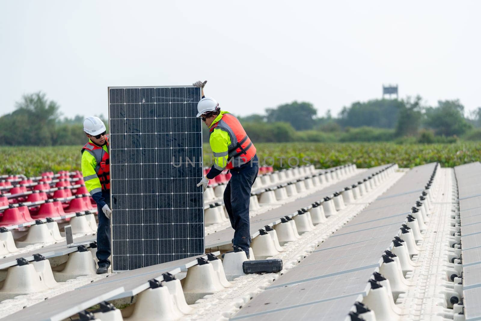 Front view of professional technician workers stand and hold solar cell panel to check and maintenance in concept of green energy for power plant.