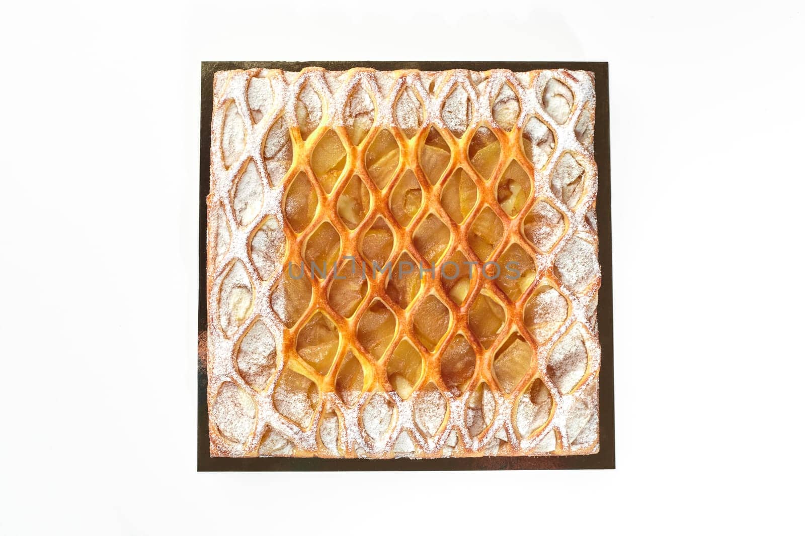 Appetizing artisan crafted pie with caramelized apple slices and custard layer topped with golden lattice, lightly dusted with powdered sugar, top view isolated on white background