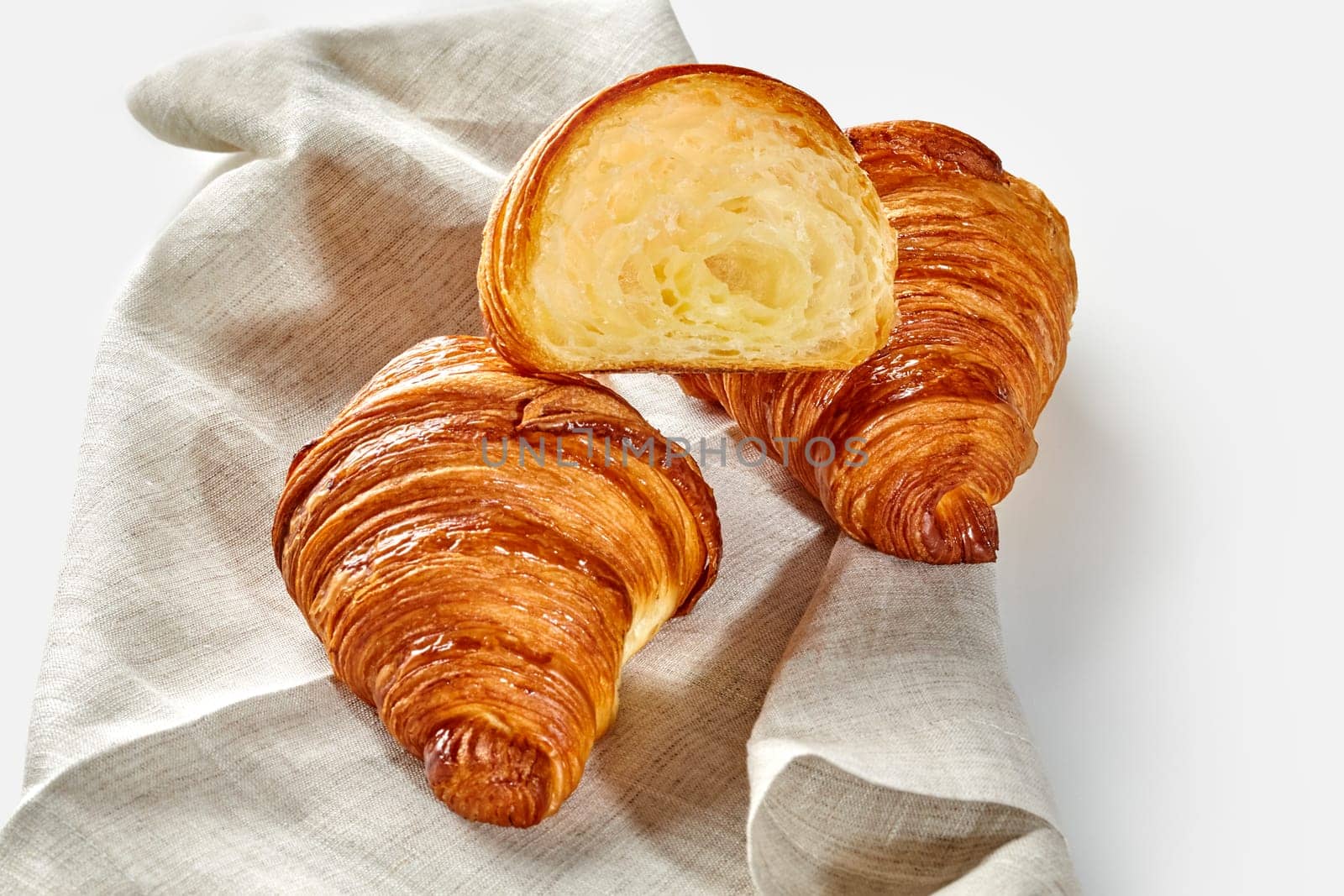 Traditional flaky French croissants on woven linen cloth by nazarovsergey