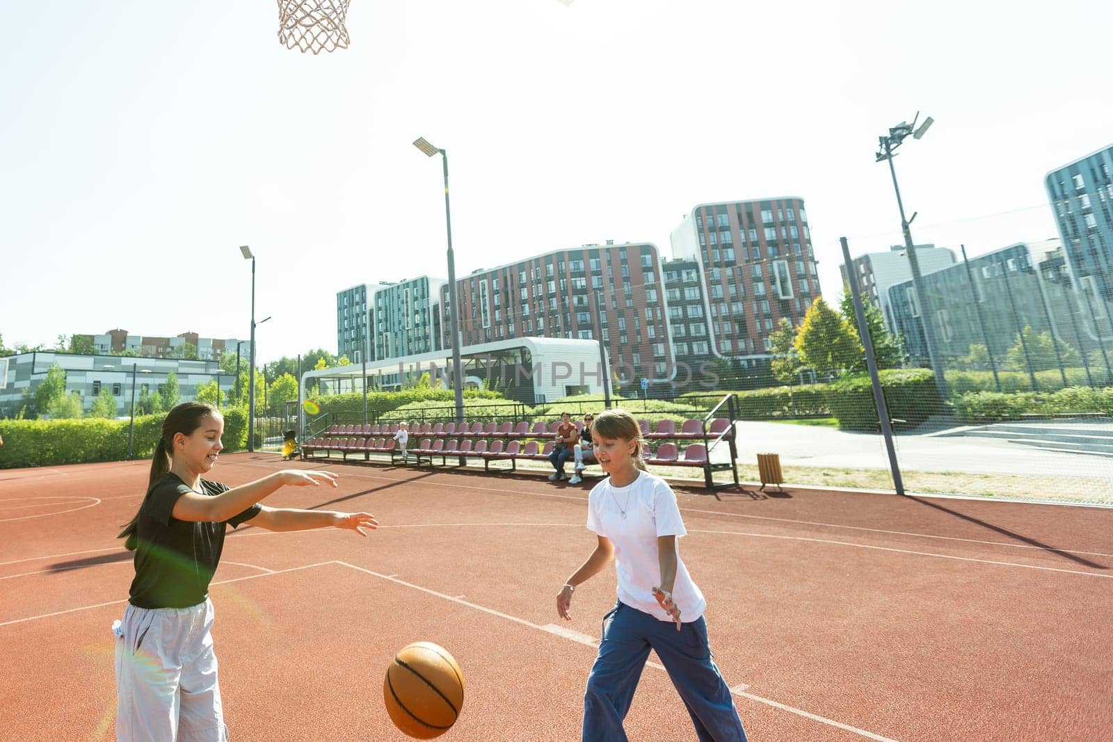 Teenager girl street basketball player with ball on outdoor city basketball court. by Andelov13