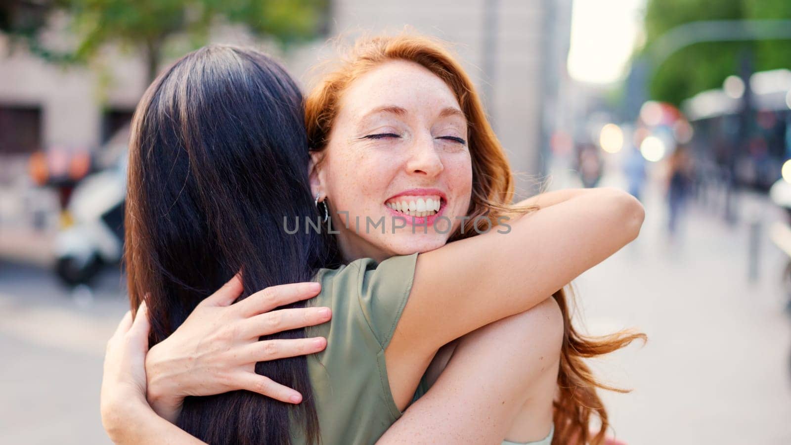 Two woman friends embrace effusively at a meeting