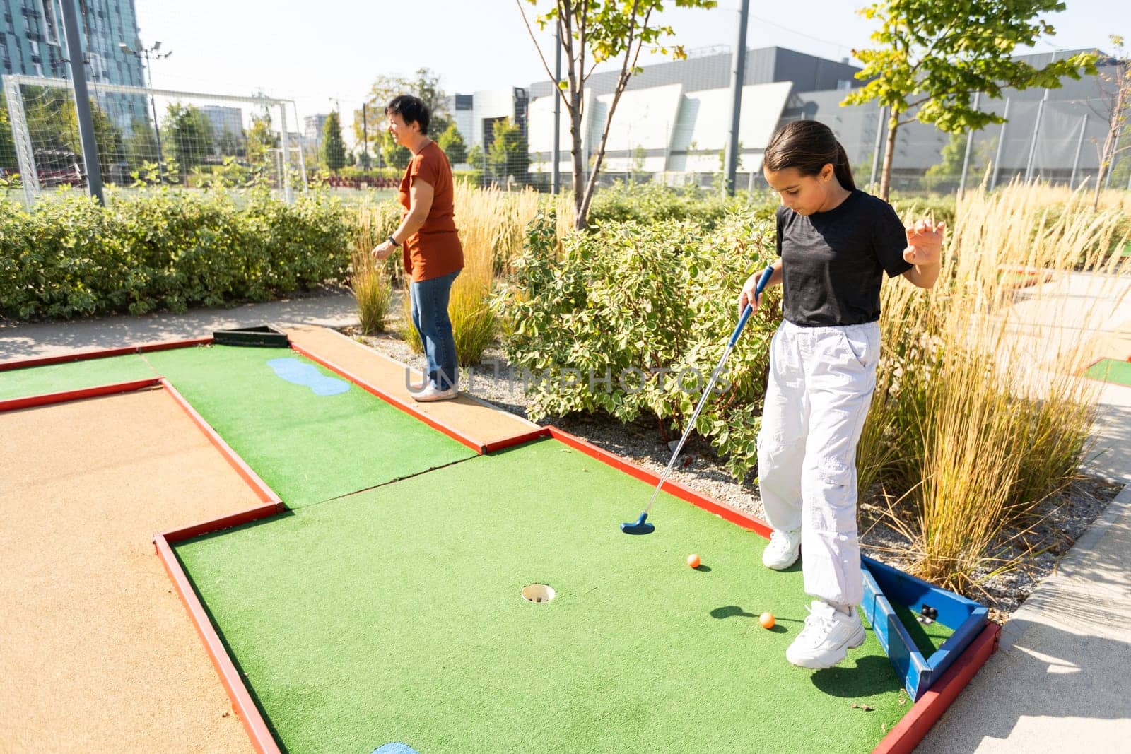 Kids playing golf inside playground artificial grass activity game for children . High quality photo