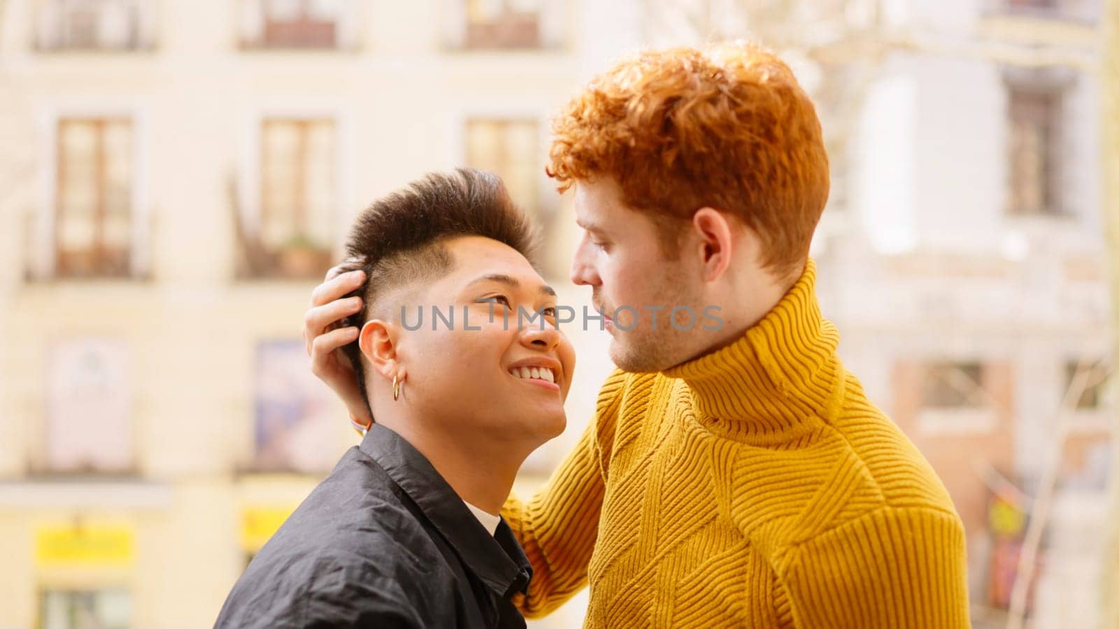 Young gay couple about to kiss on the balcony