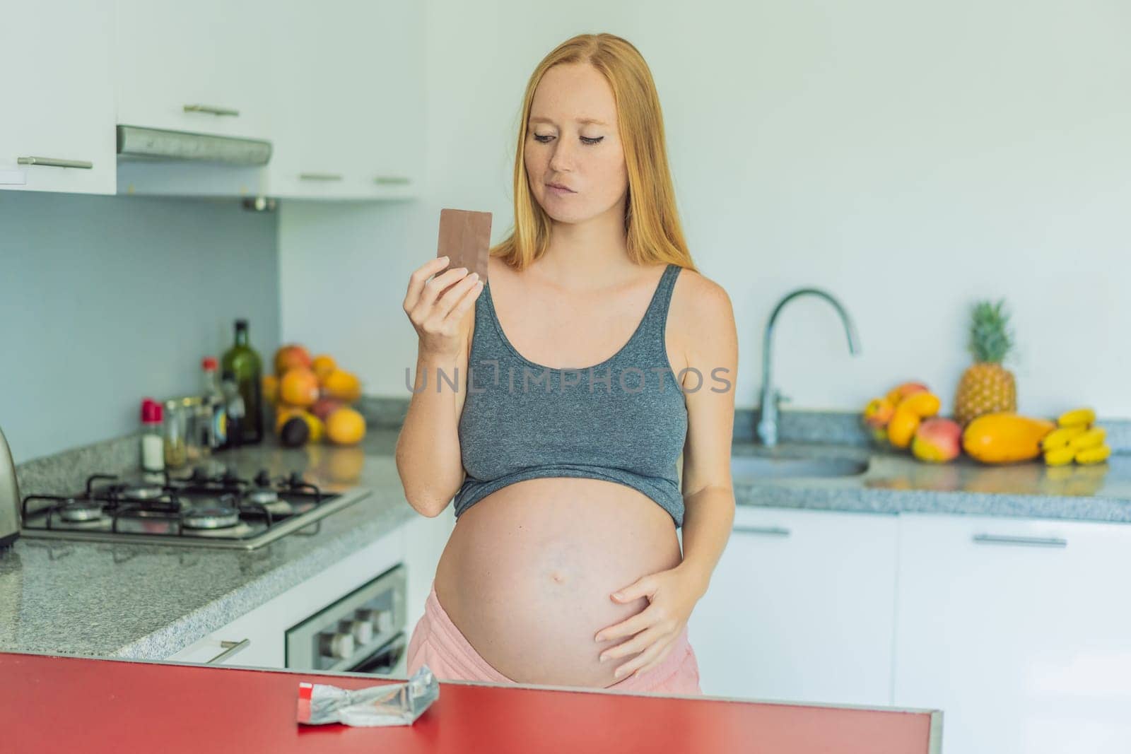 Contemplating the sweet dilemma, a pregnant woman ponders the decision to indulge in chocolate during pregnancy, weighing the delightful treat's potential impact on her maternal journey by galitskaya