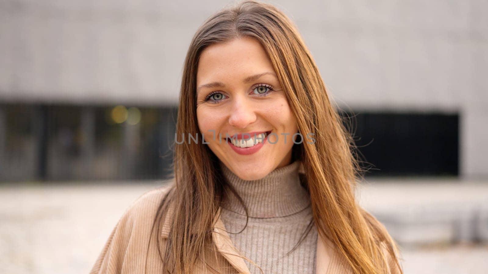 Caucasian and young female student smiling at camera outdoors