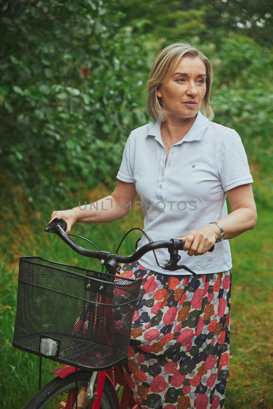 Aalborg, Denmark, July 10, 2022: Beautiful mature woman riding a bicycle