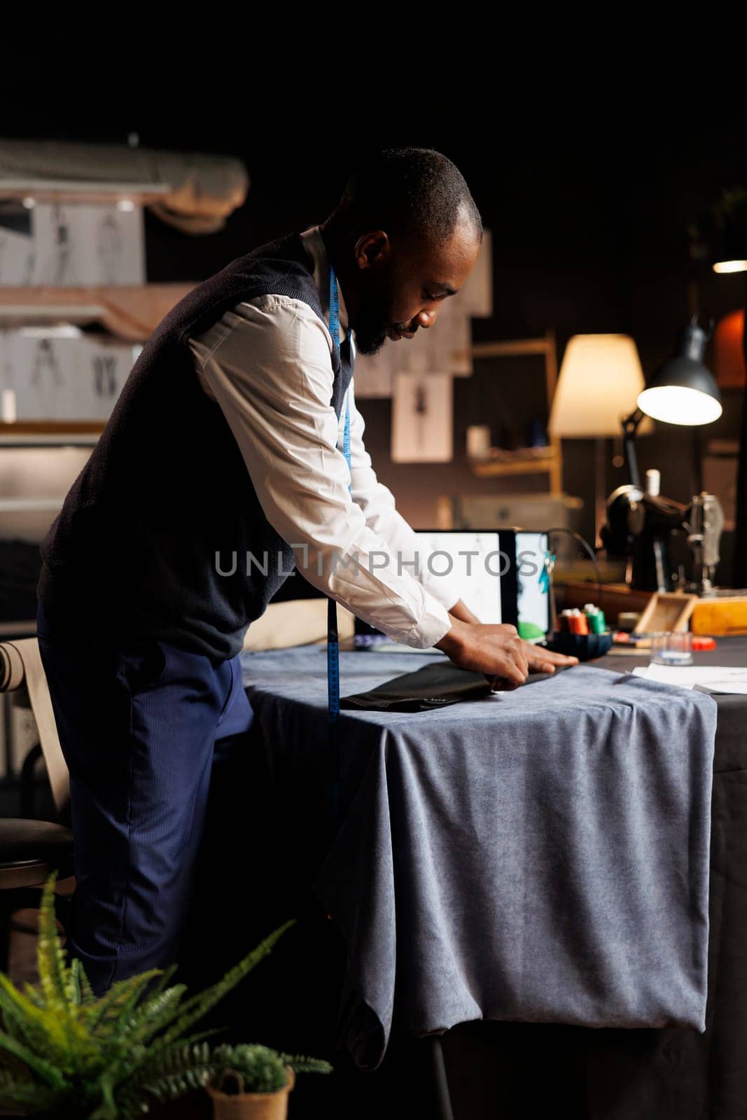 Suitmaker working on suit blazer by DCStudio