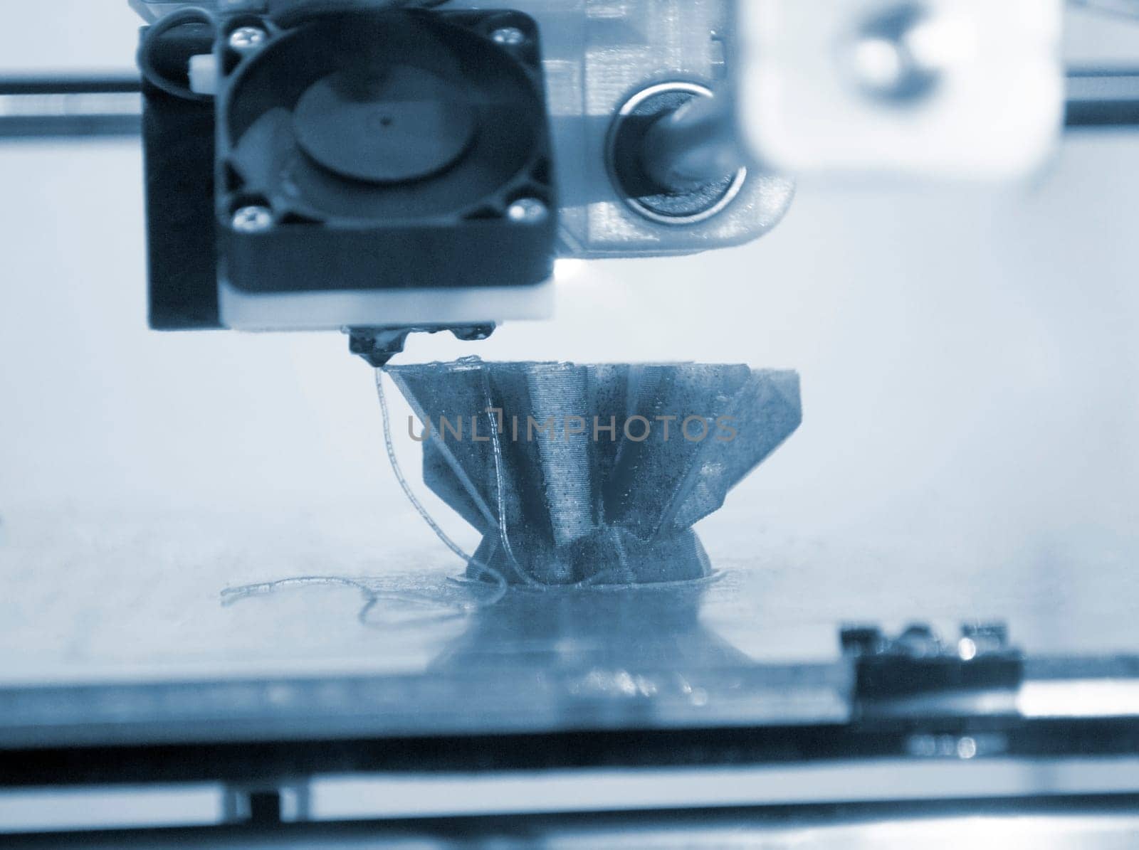 The process of printing an object with 3D printer. 3D printer printing a model from molten plastic. 3D printing. Robotic creation of mold form. Automated creation prototyping of 3D printers technology