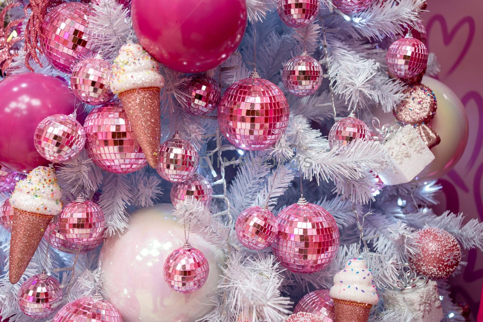 Closeup of Christmas tree decorated with pink shiny balls and icecreams by andreonegin