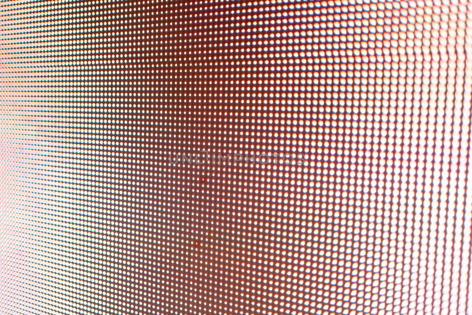 Abstract light gradient texture displayed on an LED screen with red color palette, creating visually dynamic abstract background texture.