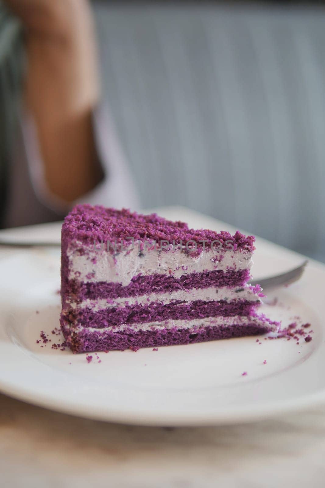 cutting A piece of purple velvet cake with cream .