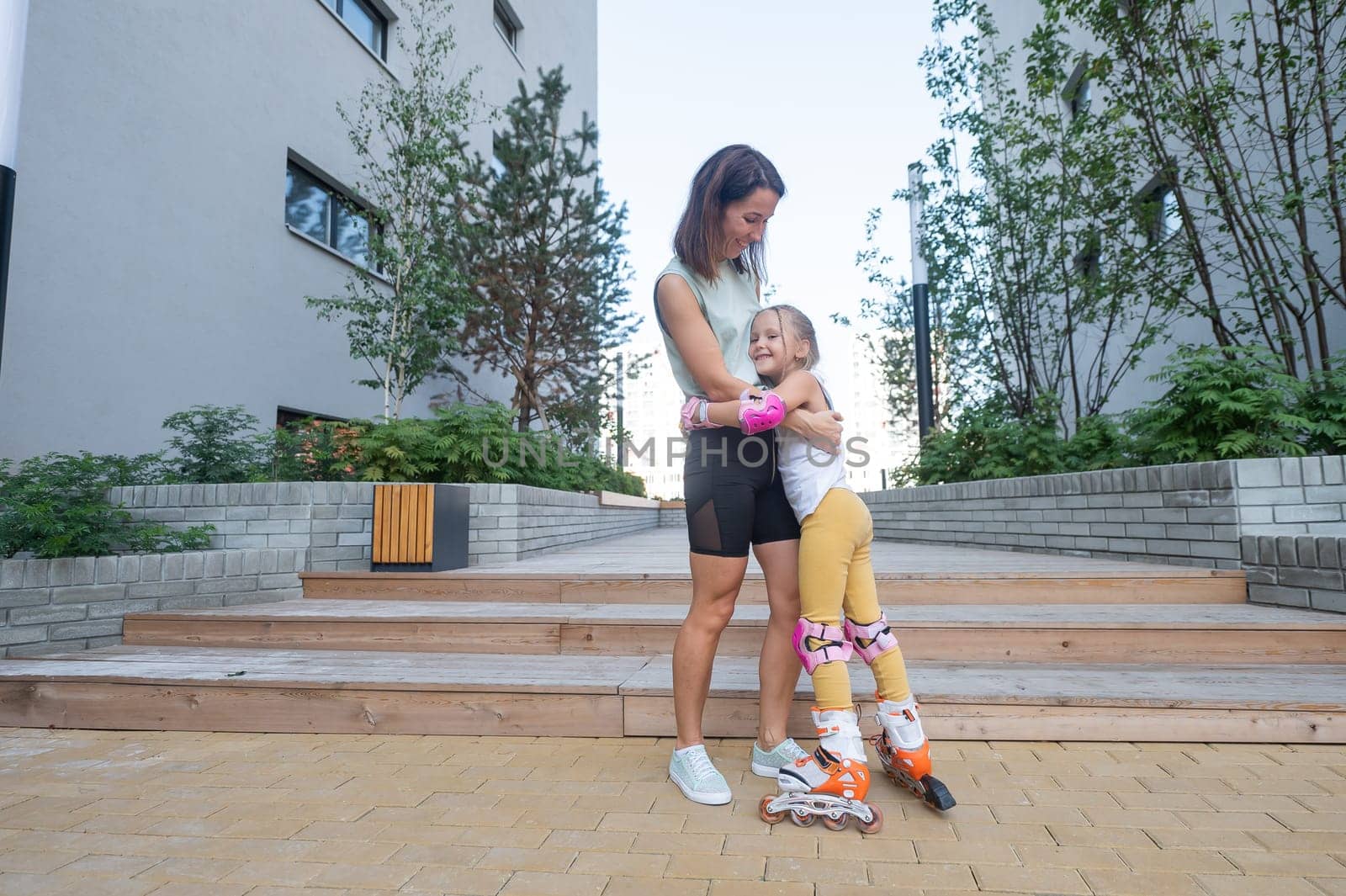 Mother helps daughter learn to roller skate