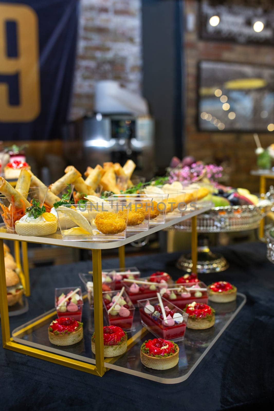 buffet table with a black tablecloth with various snacks and treats catering.