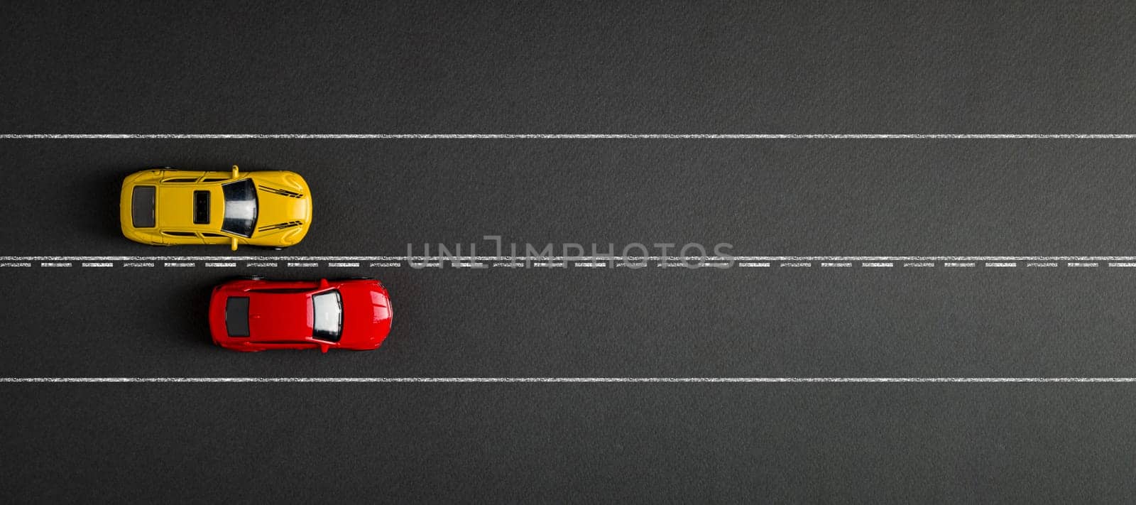 Two toy cars are racing on a dark gray background. competition concept by Sonat