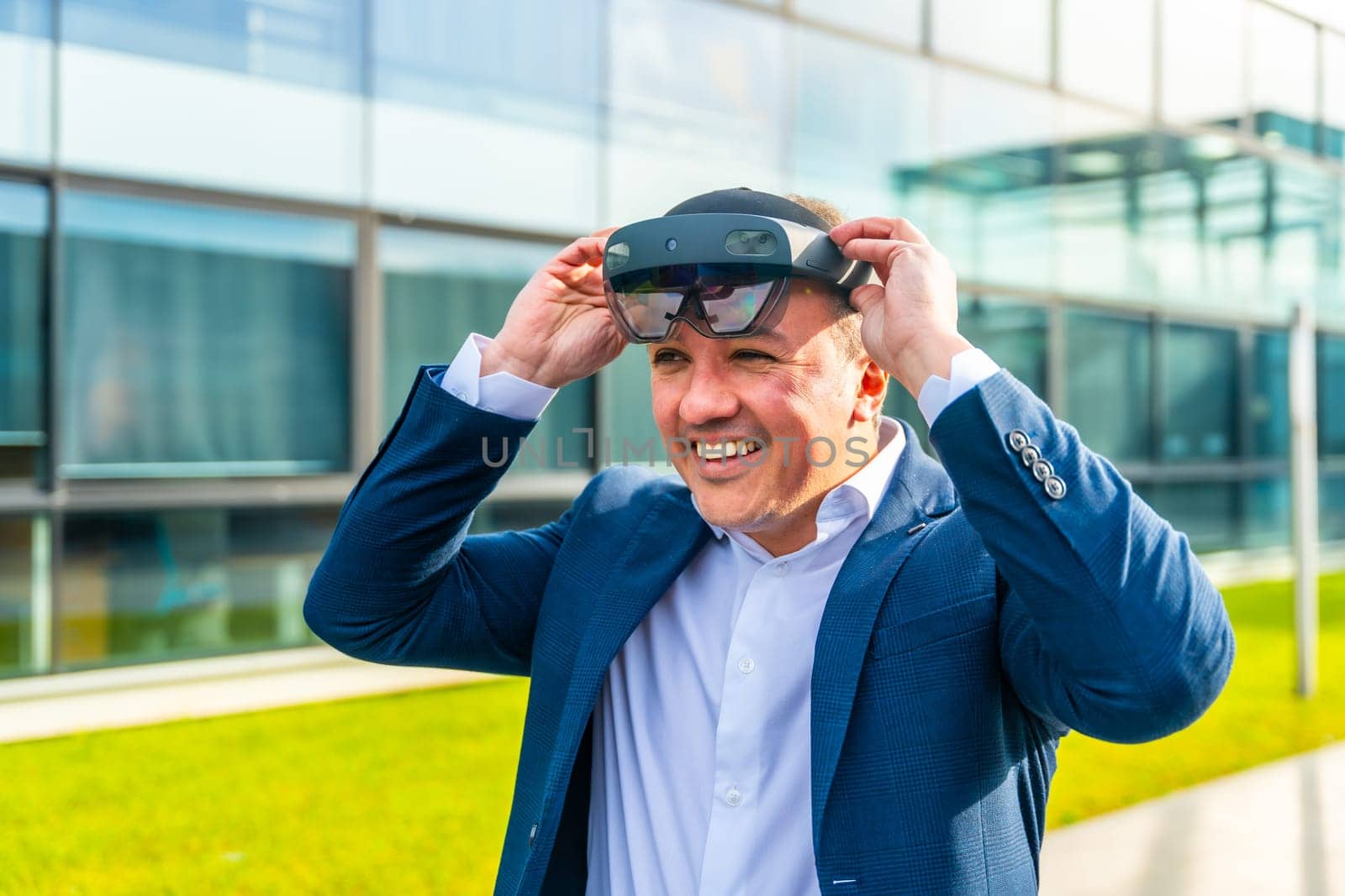Businessman putting on virtual reality headset outdoors by Huizi