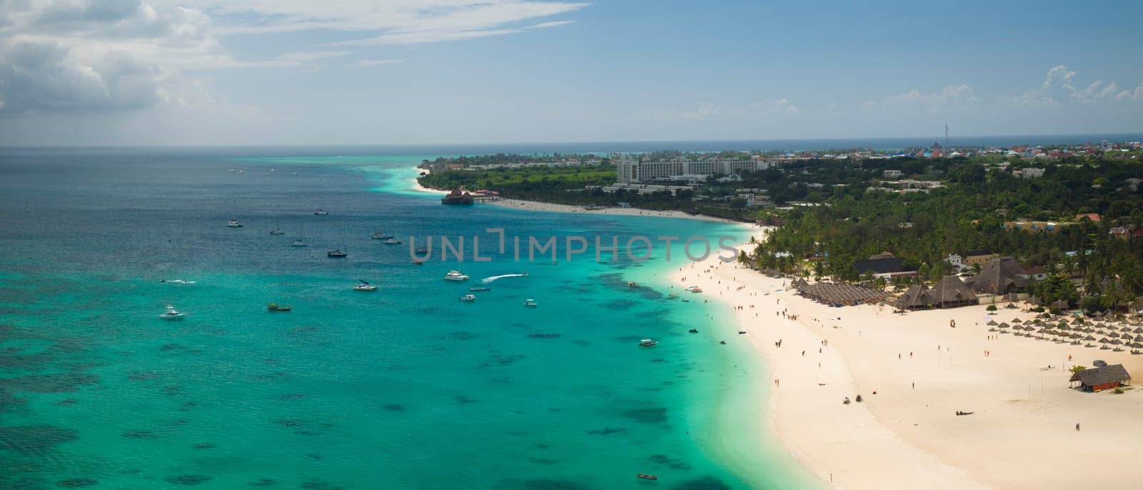Zanzibar beach where tourists and locals mix together of colors and joy, concept of summer vacation, aerial view of Kendwa beach, Tanzania