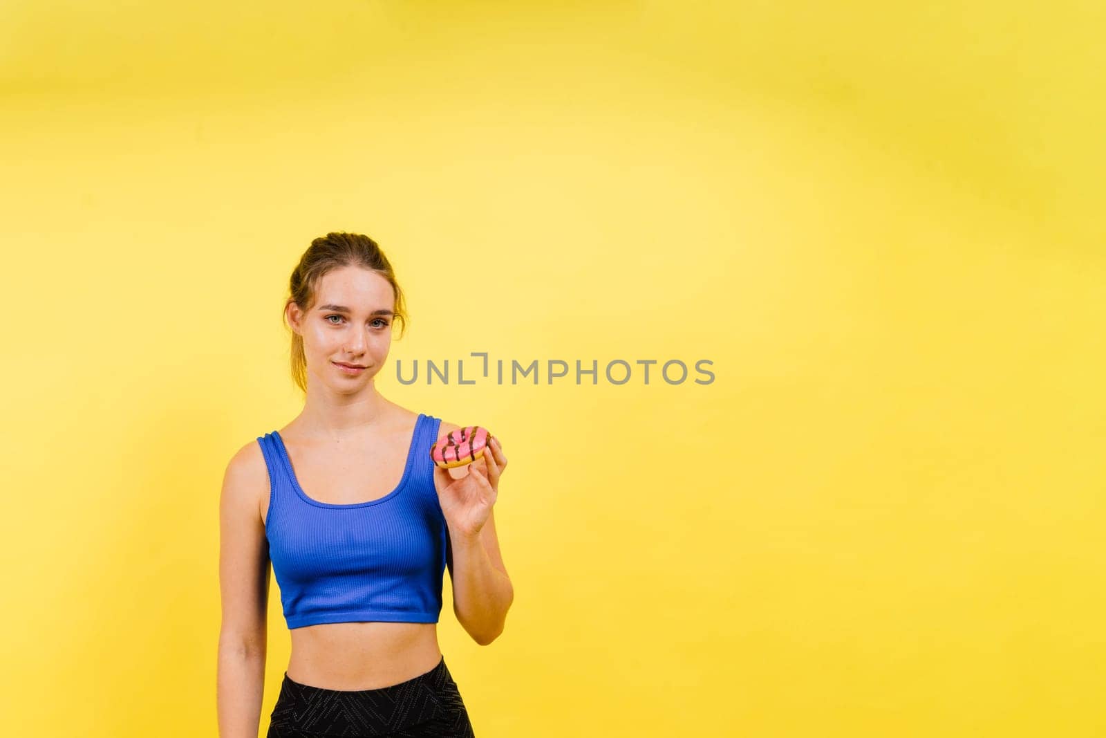 Portrait of beautiful female with chocolate donuts enjoying and looking at the camera