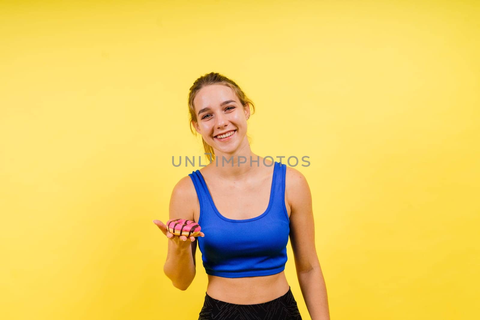 Portrait of beautiful female with chocolate donuts enjoying and looking at the camera