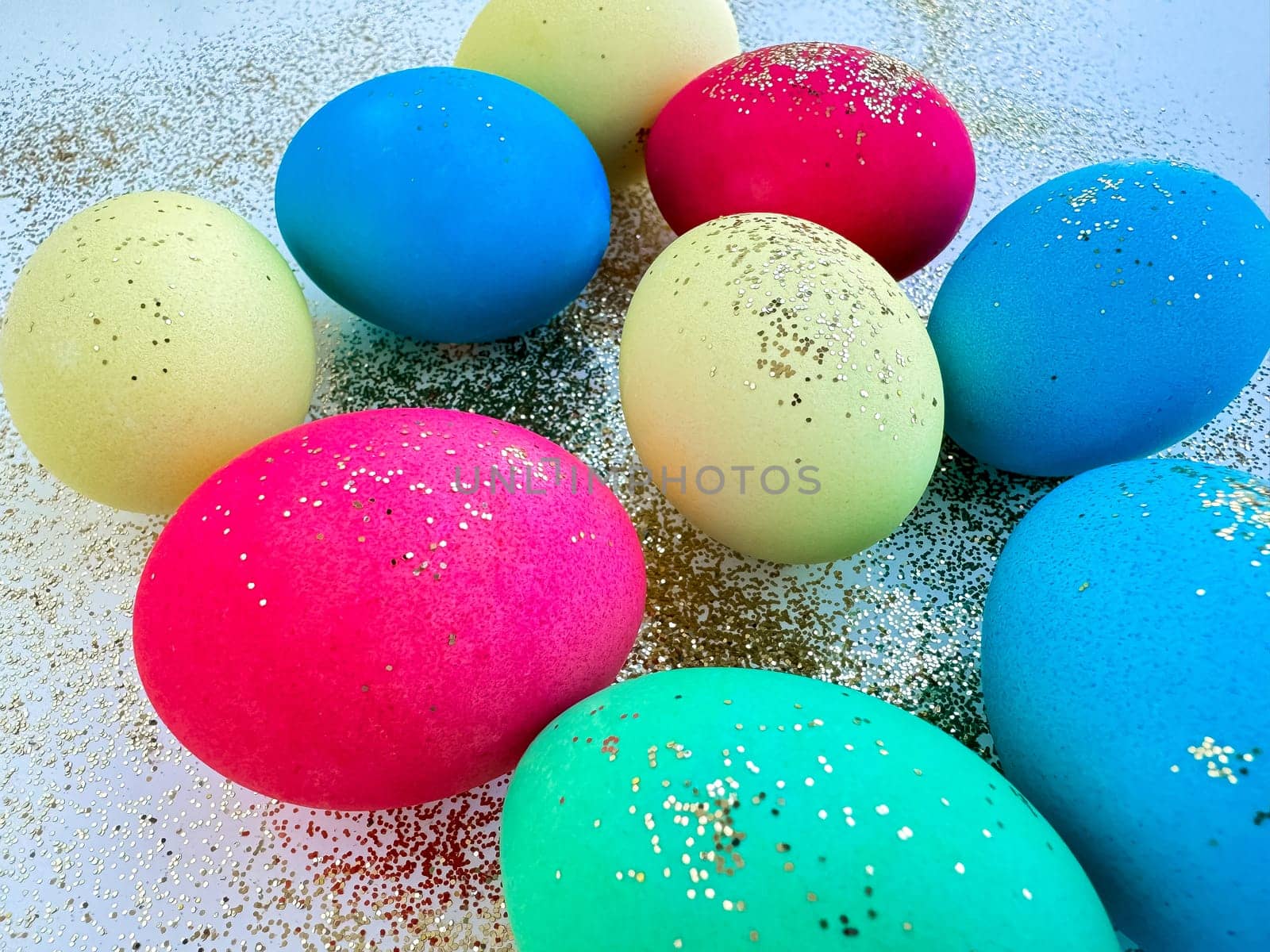 Colorful Easter eggs with glitter on a sparkling background, festive holiday decoration and celebration concept with copy space. Can be used for seasonal greeting cards, holiday party invitations, festive decoration ideas, DIY crafting tutorials, Easter themed marketing campaigns, and spring event announcements. by Lunnica