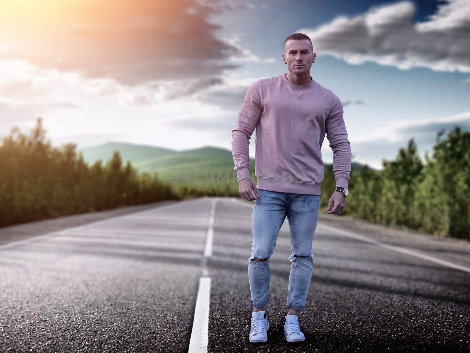 A man stands alone in the center of an empty road, surrounded by silence and solitude. The vast expanse of the road stretches into the distance, emphasizing the mans isolation.